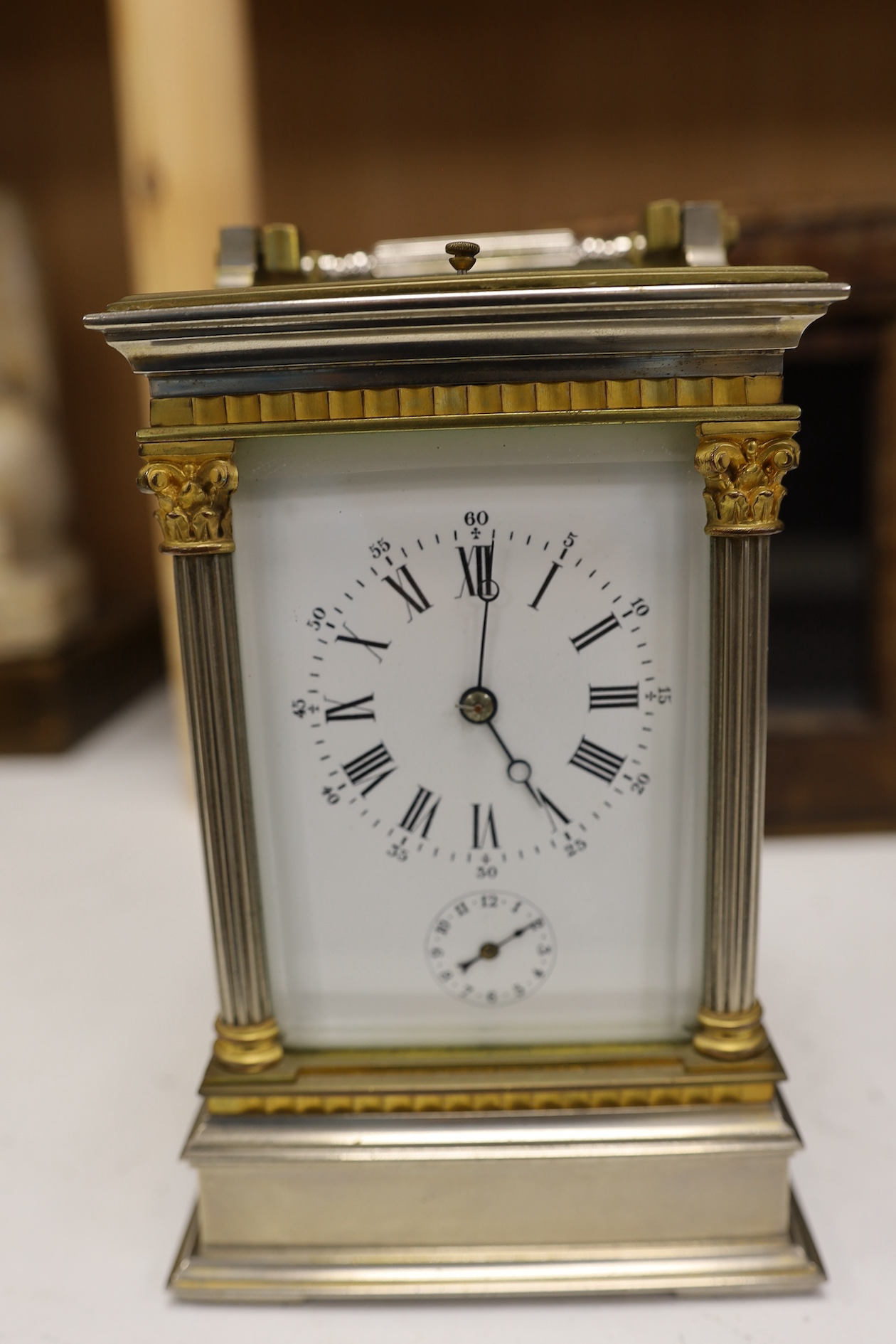 A carriage clock, in leather case, 18cm high. Condition - gilding worn and surface slightly pitted in places